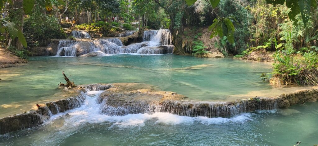 Mehrstufige türkisfarbene Kuang Si Wasserfälle im Dschungel von Luang Prabang Laos.