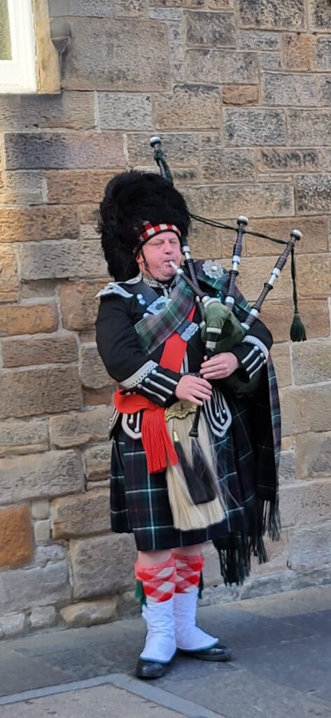 Ein Schotte in traditioneller Kleidung beim Dudelsack spielen