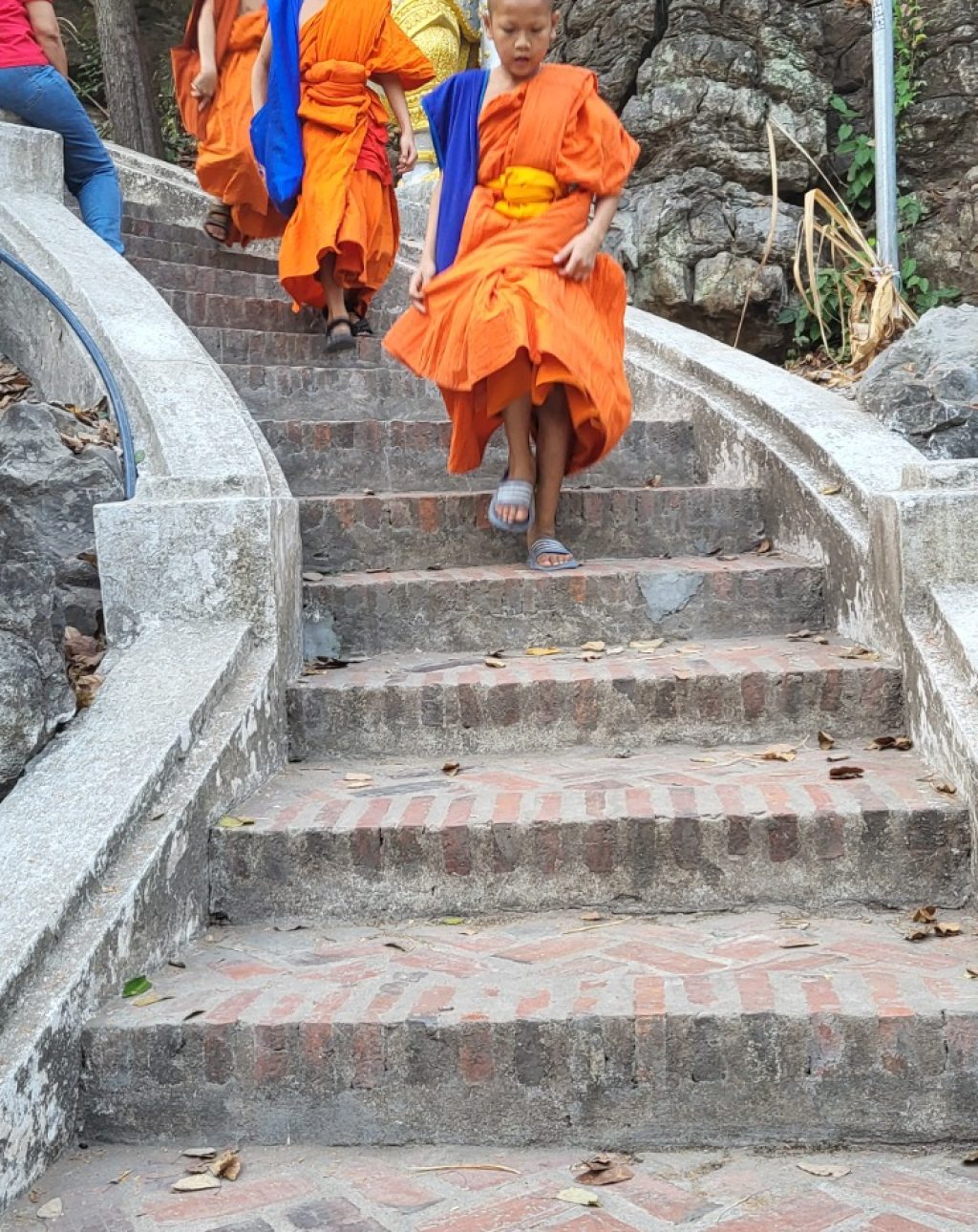 Mönche in orangener Kleidung die vom Phousi Hill herunterkommen